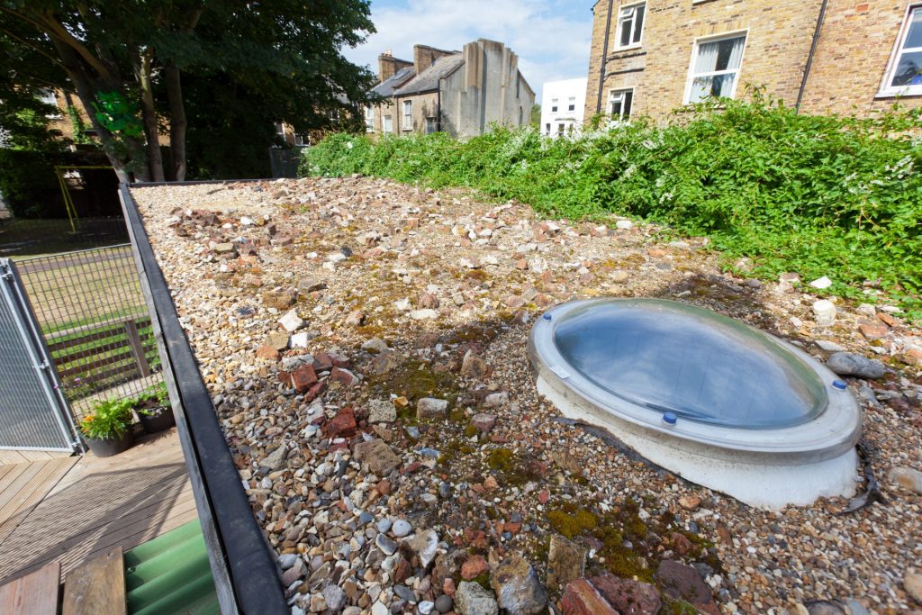 Rubble roof with circular rooflight on community project