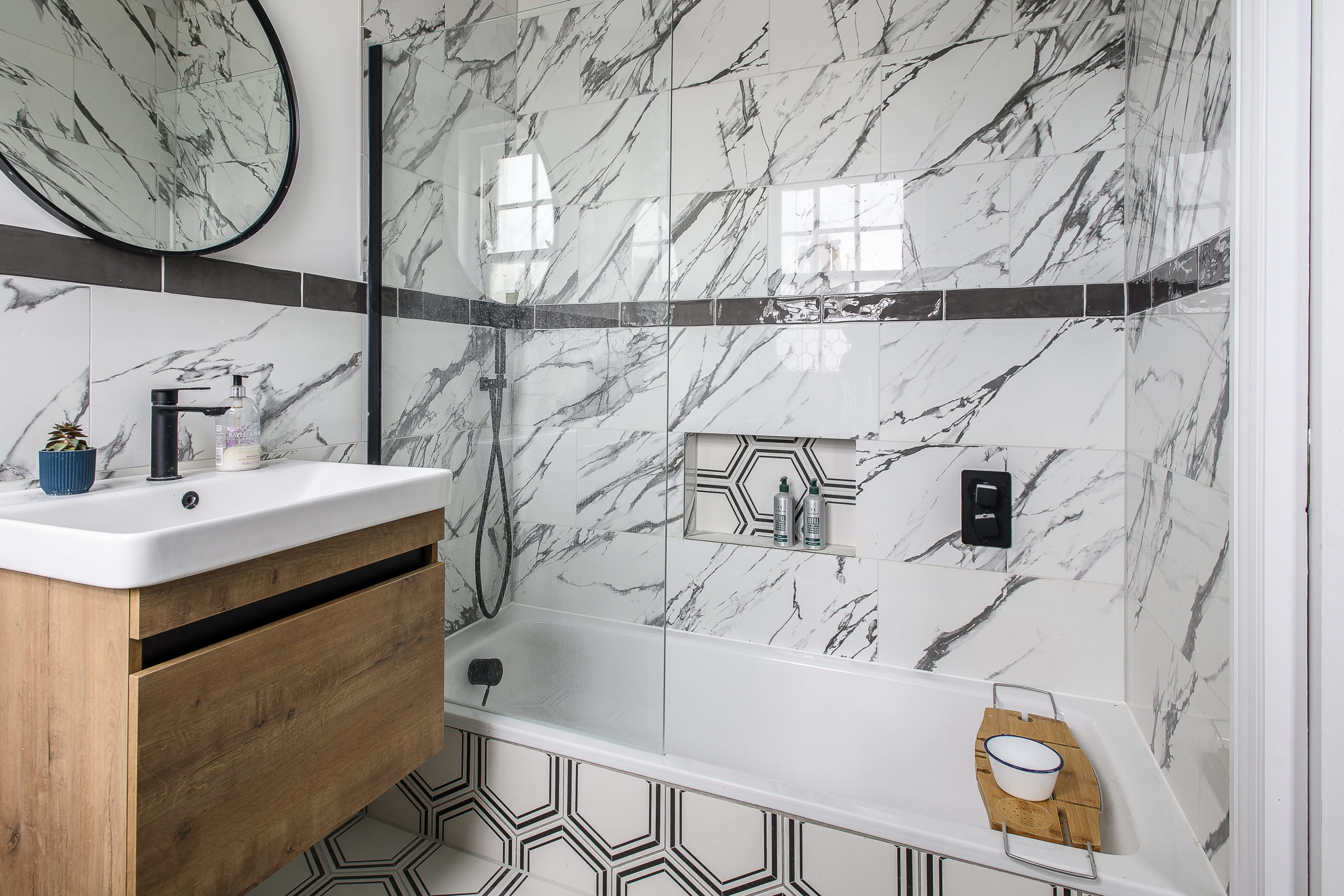 Bathroom Design Contemporary bathroom design with marble-effect wall tiles, geometric floor tiles, bespoke vanity unit and frameless glass shower screen by Shape Architecture.