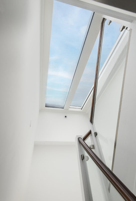 Internal stair viewed through a large rooflight, allowing natural daylight to flood the stairwell in a contemporary residential project.