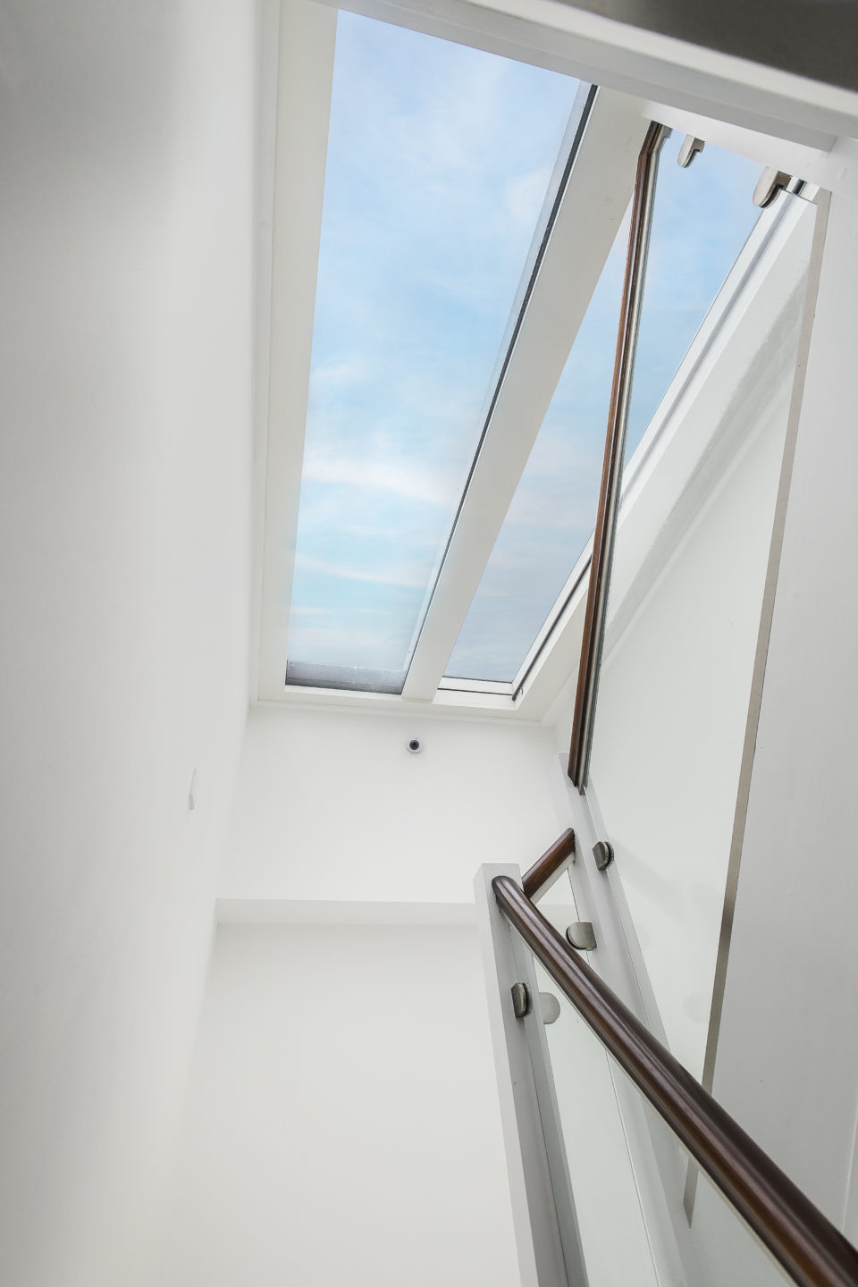 Internal stair viewed through a large rooflight, allowing natural daylight to flood the stairwell in a contemporary residential project.